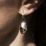 artistic silver earrings on ear