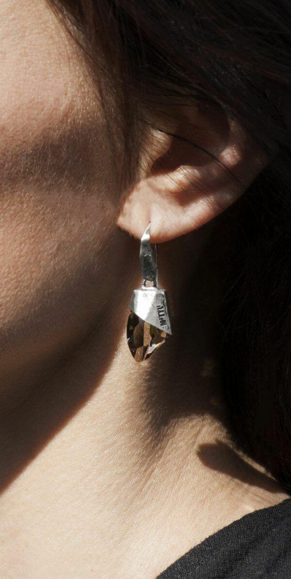 artistic silver earrings on ear